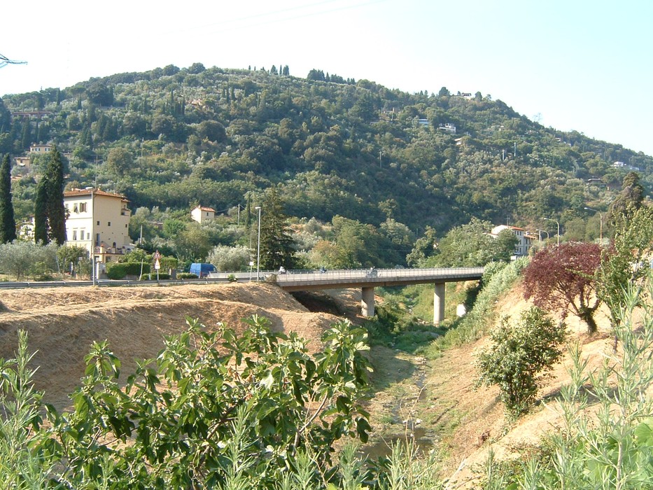 Vista panoramica del Cippo del ponte a Bracci, con un paesaggio collinare e vegetazione verdeggiante.