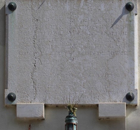Lapide commemorativa dedicata ai caduti per la Libertà di Trasta, con dettagli in evidenza sulla parete.