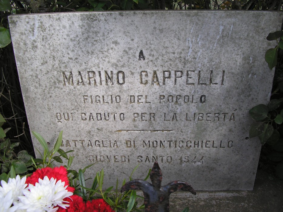 Cippo commemorativo dedicato a Marino Cappelli, eroe della libertà, decorato con fiori.