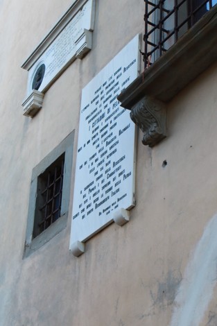 Lapide commemorativa che celebra un decennale, affissa su una parete storica.