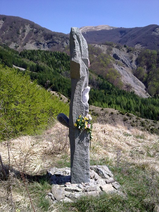 Monumento commemorativo a Fiorini, Giovannini e Donadelli, immerso nella natura montana.