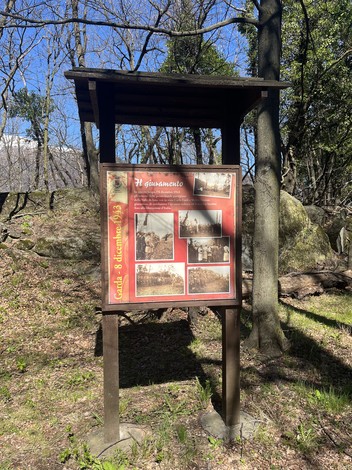 Targa commemorativa che celebra il giuramento, circondata dalla natura e da rocce.