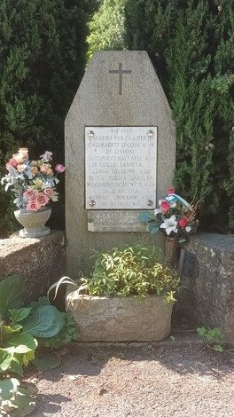 Monumento ai caduti per la Libertà di Coldimosso, decorato con fiori e posto tra alberi verdi.