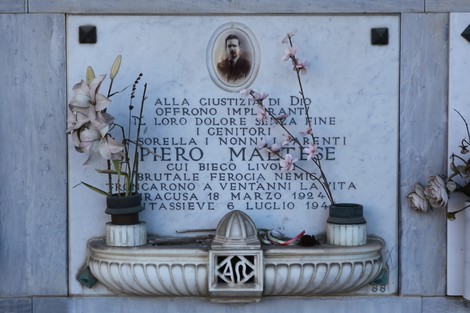 Sepolcro di Maltese con decorazioni floreali e foto commemorativa, in onore di un defunto.