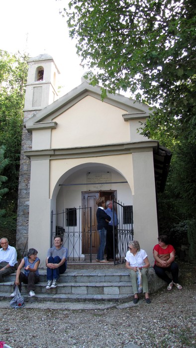 Lapide commemorativa a Negruzzi, con un edificio semplice immerso nella natura e visitatori in relax.