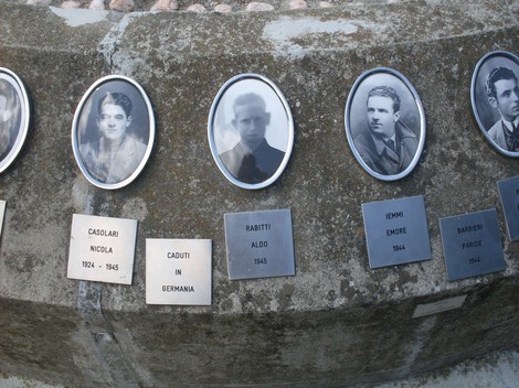 Monumento alla Pace e alla Libertà: ricordo dei caduti con ritratti e nomi su lastre commemorative.