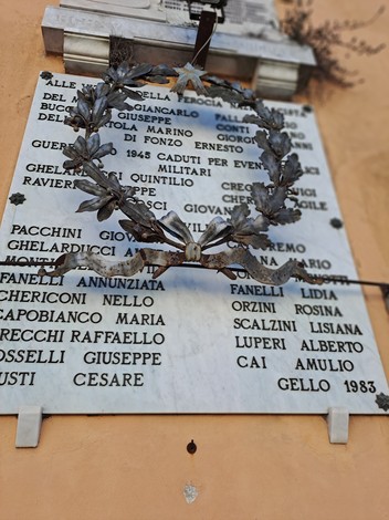 Lapide commemorativa con decorazione floreale, dedicata ai caduti di Gello.