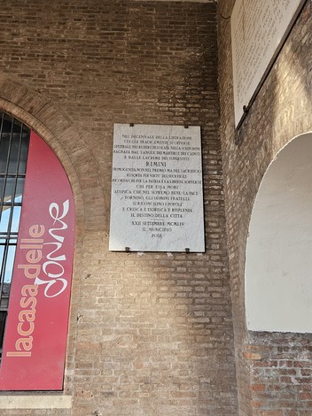 Lapide commemorativa per il decennale della Liberazione, situata in un contesto storico a Rimini.