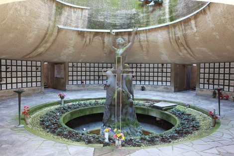 Monumento Ossario dedicato ai caduti partigiani, con statue e fiori in un ambiente commemorativo.