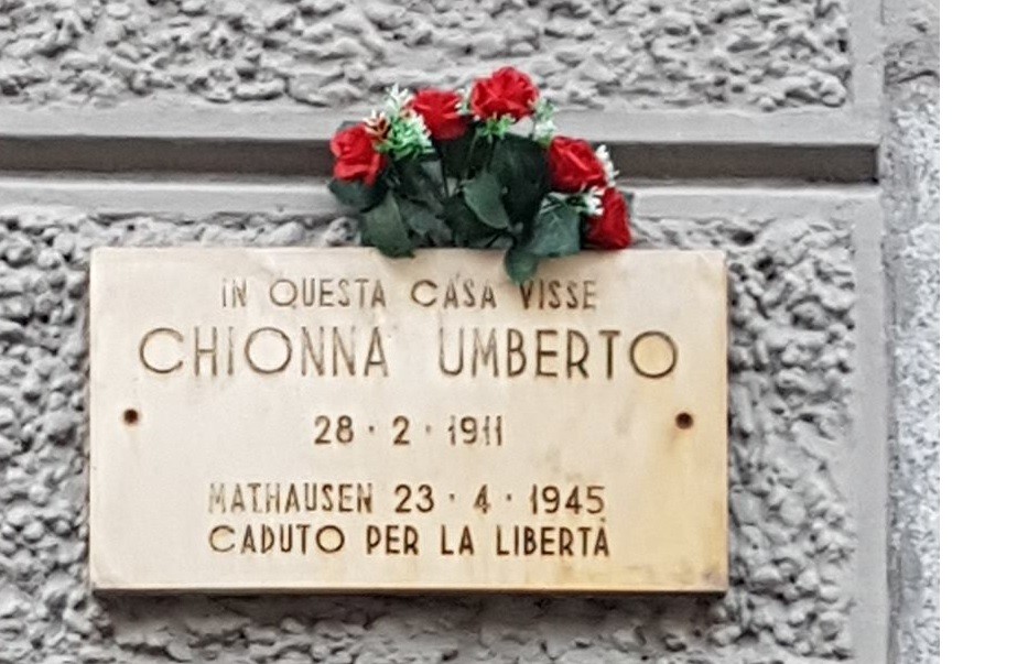 Lapide commemorativa di Chionna Umberto, con fiori rossi, in ricordo della libertà.