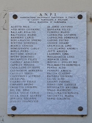 Lapide commemorativa dedicata ai caduti e partigiani della Madonna di Campagna, con elenco di nomi.