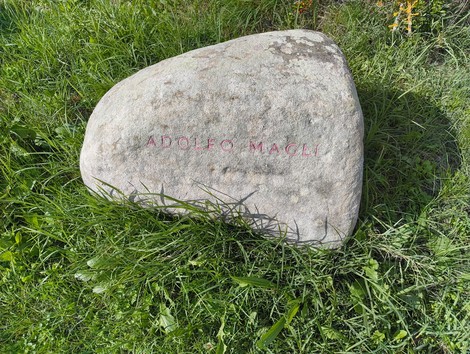 Monumento in memoria dei partigiani caduti a Monte Sabbiuno, con un messaggio commemorativo inciso su una pietra.