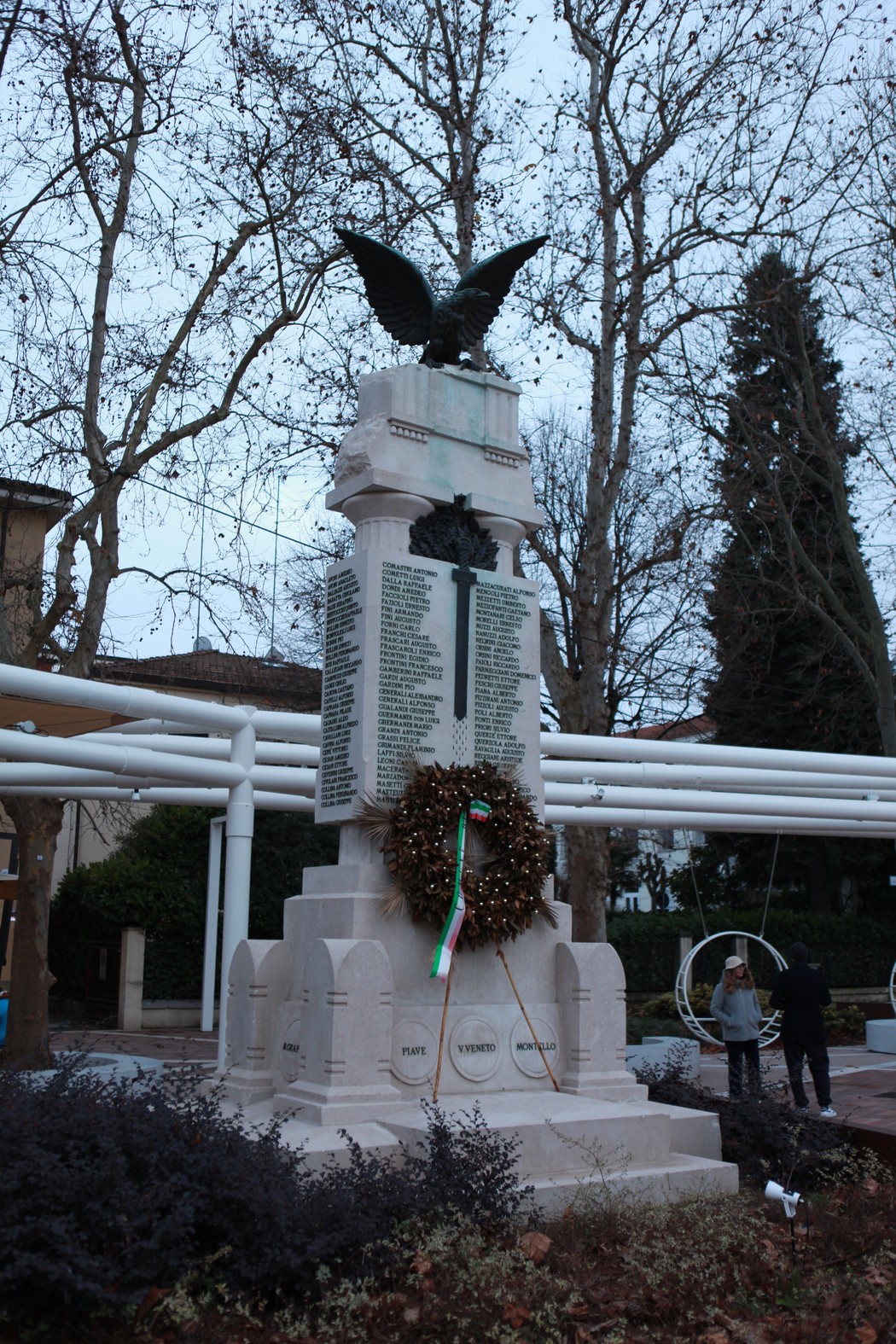 Monumento ai caduti di San Lazzaro di Savena, con un'aquila e una corona d'alloro. Atmosfera serena e commemorativa.