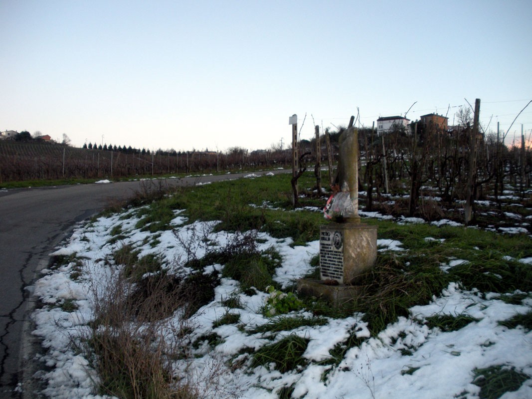 Cippo a Rinaldi: monumento tra i vigneti, circondato da neve e un'atmosfera di tranquillità.