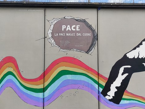 Murale di Pioppe che promuove un messaggio di pace e unità attraverso colori vivaci e simboli rappresentativi.