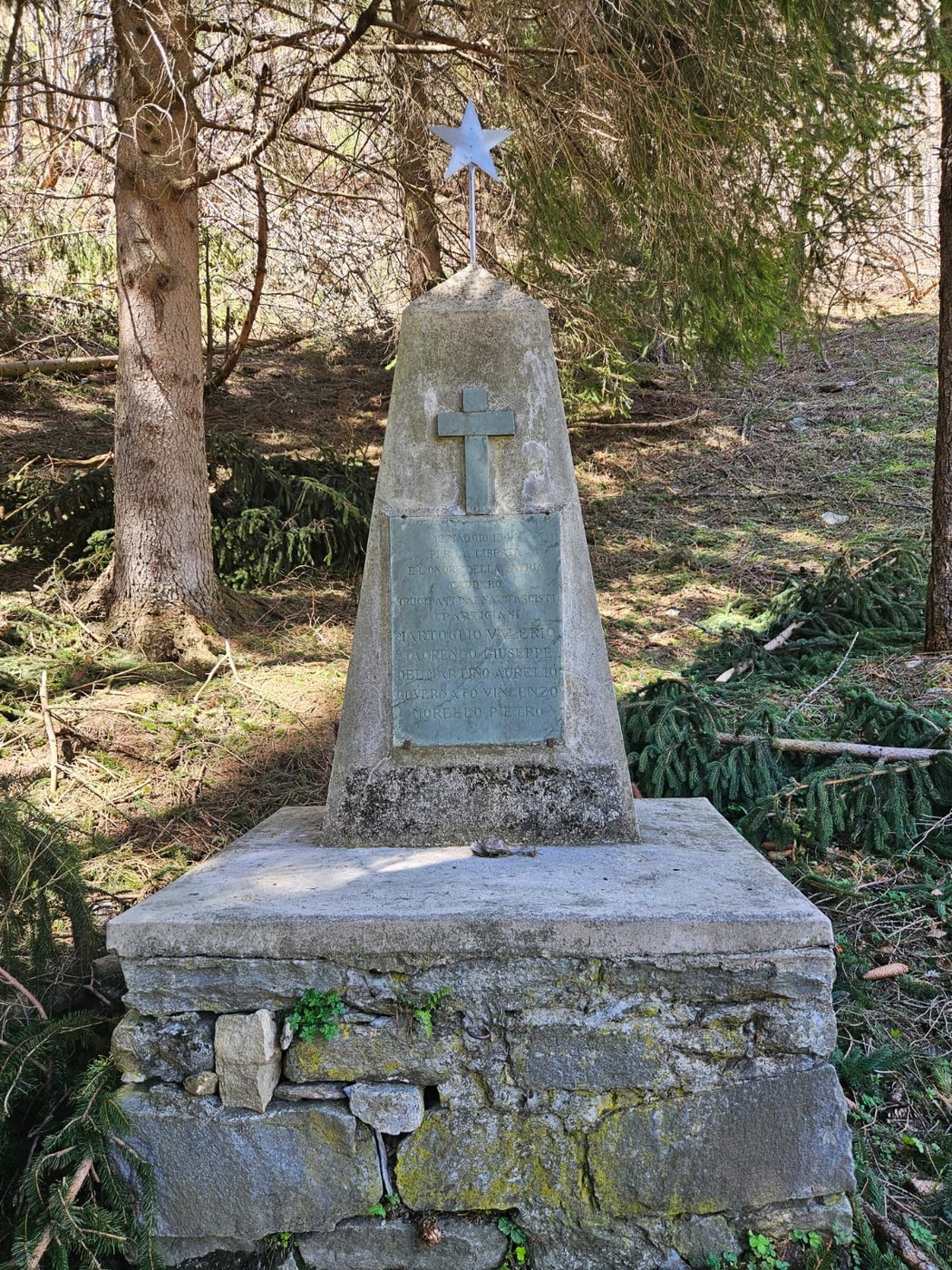 Cippo commemorativo dedicato ai caduti, immerso nella natura, simbolo di memoria e rispetto per gli eroi.