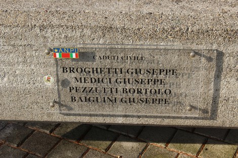 Monumento ai caduti partigiani con targhe commemorative di diversi nomi su una base in pietra.