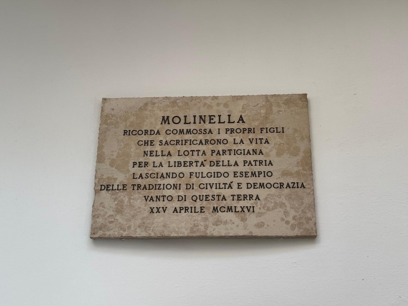 Lapide commemorativa che onora i partigiani di Molinella per il loro sacrificio nella lotta per la libertà.