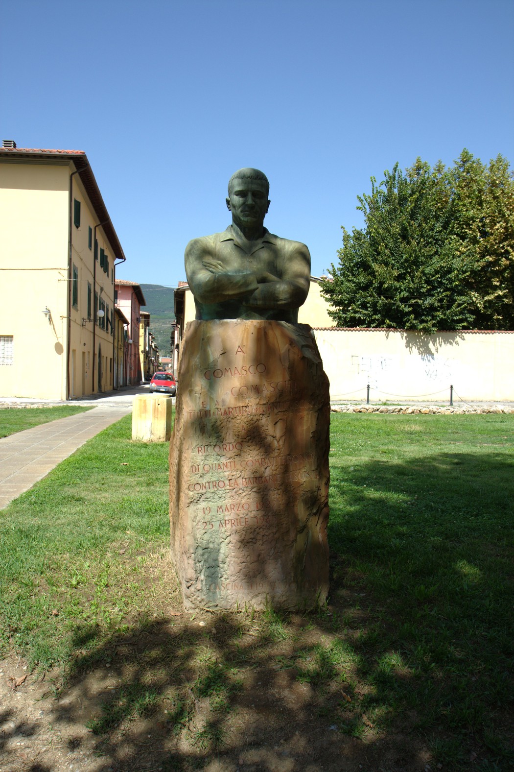 Monumento a Comaschi, statua che celebra il contributo dei cittadini di Como, immersa nel verde.