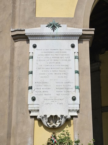 Lapide commemorativa dedicata ai caduti per la libertà, situata su un muro.