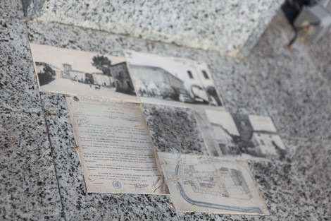Monumento alle vittime del bombardamento, con foto storiche e documenti storici collocati su una superficie.
