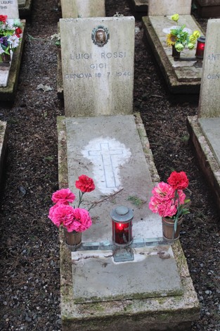 Tombe perpetue con fiori e candele, dedicate ai caduti per la Libertà. Atmosfera di ricordo e rispetto.