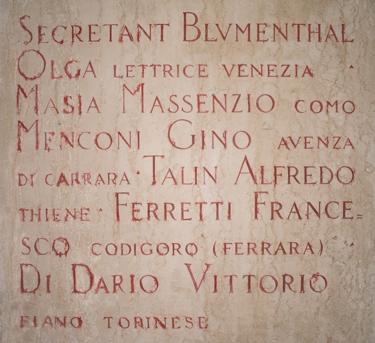 Sacrario dedicato agli studenti universitari caduti, con nomi incisi in una pietra. Atmosfera di commemorazione e rispetto.