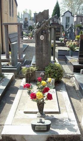 Tomba della Famiglia Oreglio con fiori colorati e decorazioni, all'interno di un cimitero ordinato.
