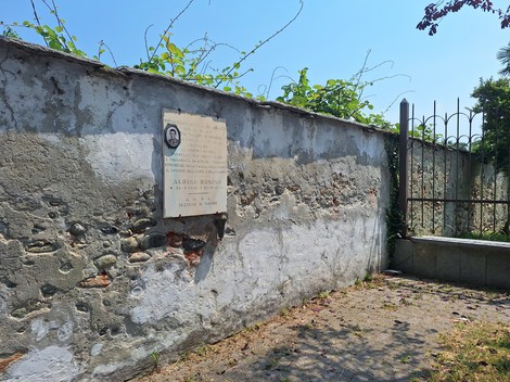 Lapide commemorativa dedicata a Bonino, situata su un muro di pietra in un contesto all'aperto.