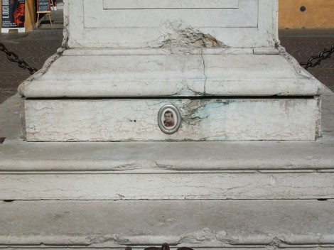 Lapide commemorativa dedicata a Filippini, con dettagli architettonici e una fotografia incastonata.
