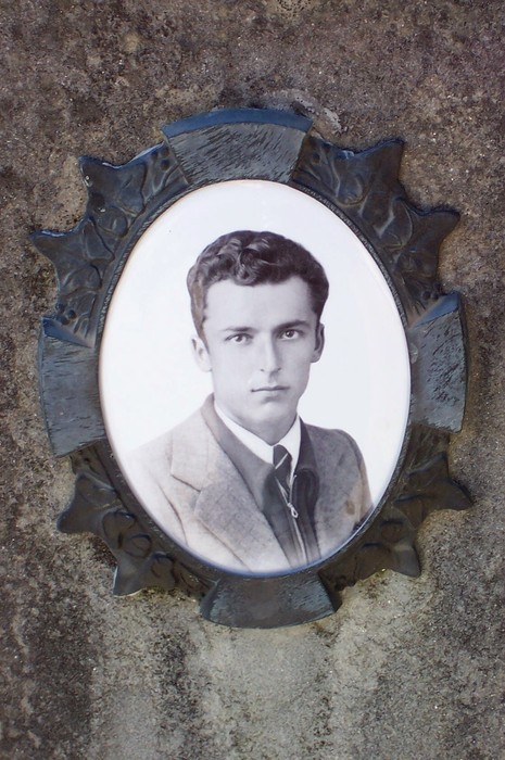 Ritratto commemorativo in un sacrario, a ricordo dei caduti di Tugliano, con un volto giovane e solenne.