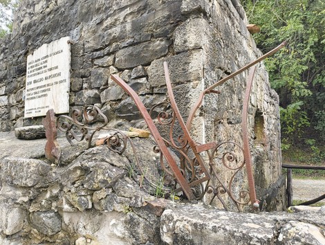Rovine della chiesa di Casaglia, testimonianza storica immersa nella natura, tra pietre e ferro arrugginito.