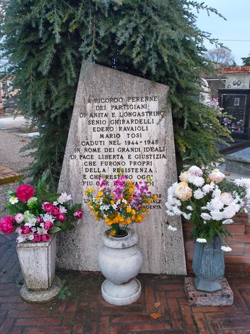Monumento commemorativo ai partigiani Ghirardelli, Ravaioli e Tosi, con fiori e lapide in memoria.