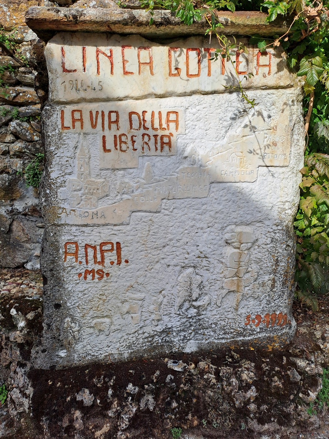 Lapide in pietra con iscrizione dedicata alla Linea Gotica e alla Via della Libertà, su muro esterno.