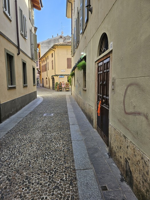 Vicolo acciottolato con palazzi e porta ad arco; la pietra d'inciampo non è visibile nell'inquadratura.