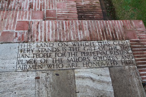 Cimitero di guerra del Commonwealth con lapide commemorativa e paesaggio curato.