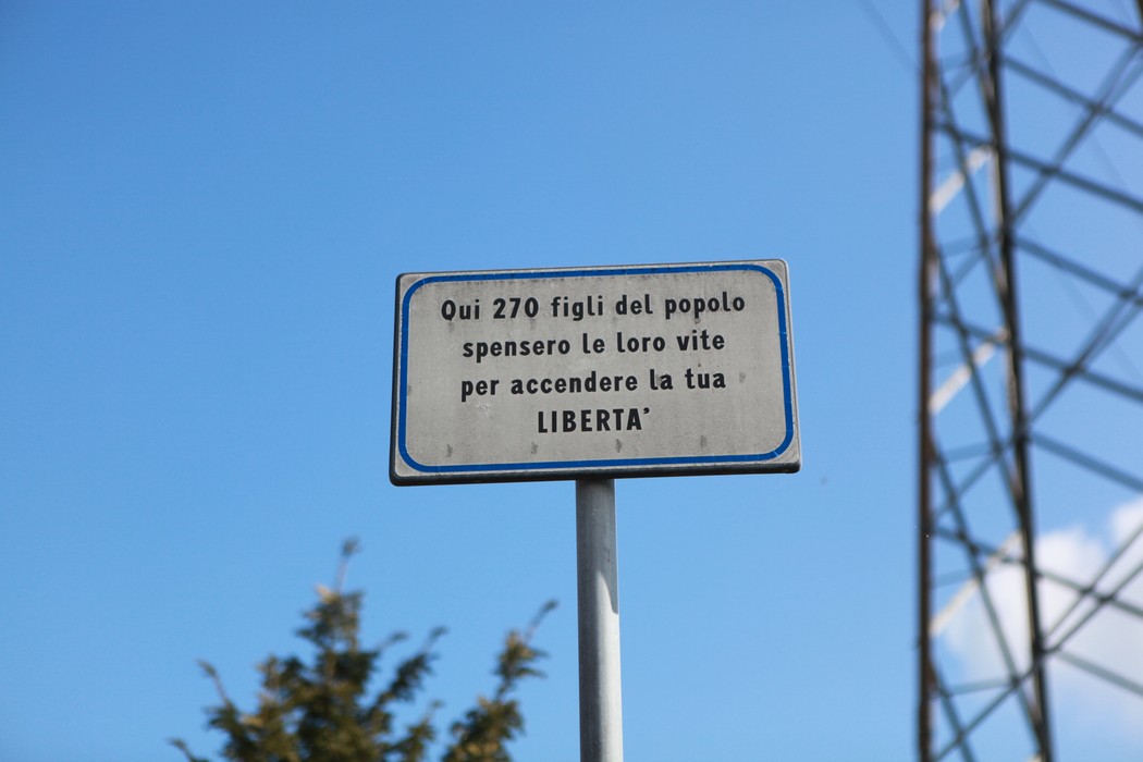 Targa commemorativa che onora i caduti del Poligono di tiro, simbolo di libertà e sacrificio.
