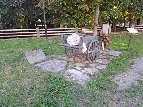 Carretto delle lavandaie in un parco, con ruote di legno e vari oggetti a simboleggiare il lavoro tradizionale.