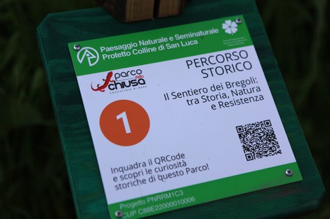 Insegna del "Sentiero dei Bregoli" con informazioni storiche e naturalistiche sul percorso nel Parco delle Colline di San Luca.