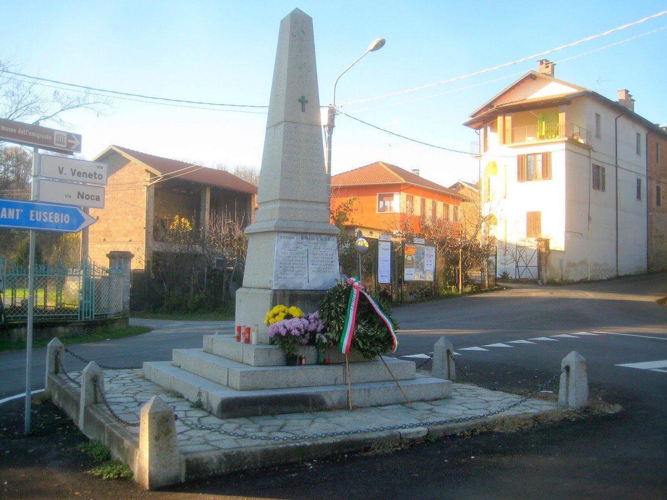 Monumento ai caduti di Sant'Eusebio, commemorazione dedicata ai valorosi del passato, con fiori e bandiera tricolore.