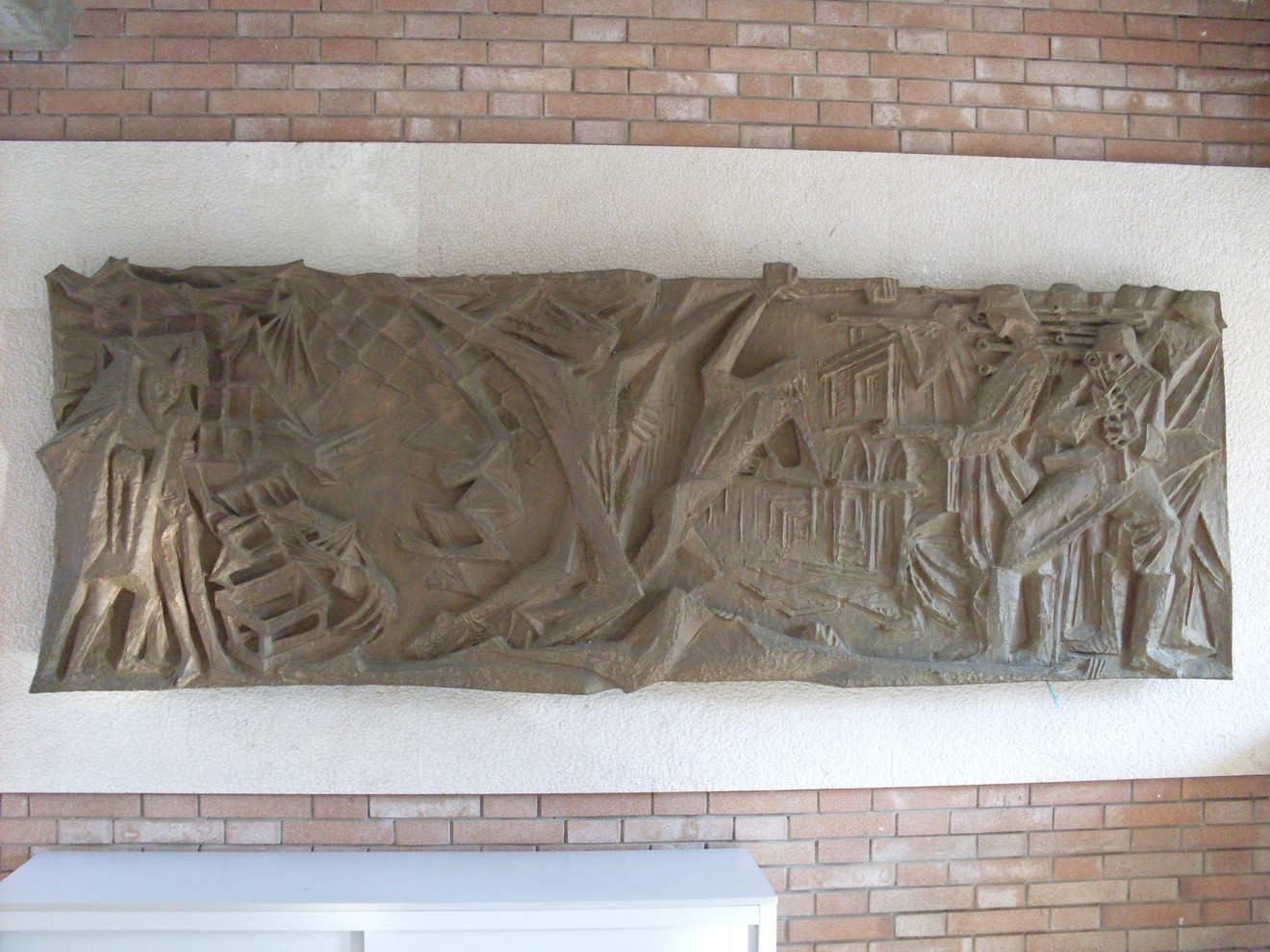 Bassorilievo che celebra la Resistenza, raffigurando figure e scene simboliche del movimento partigiano.