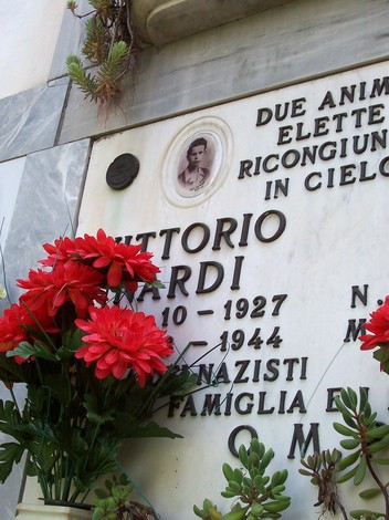 Sepolcro di Vittorio Nardi, con fiori rossi e una foto, in memoria del giovane caduto nel 1944.