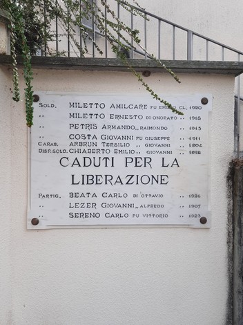 Lapide commemorativa dedicata ai caduti per la liberazione, con nomi e date di militari e partigiani.