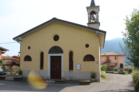 Lapide commemorativa su edificio di un luogo pubblico, con architettura semplice e contesto tranquillo.