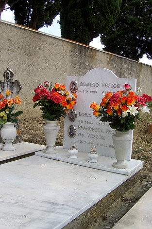 Tomba dei fratelli Vezzosi, decorata con fiori colorati e in un contesto tranquillo.