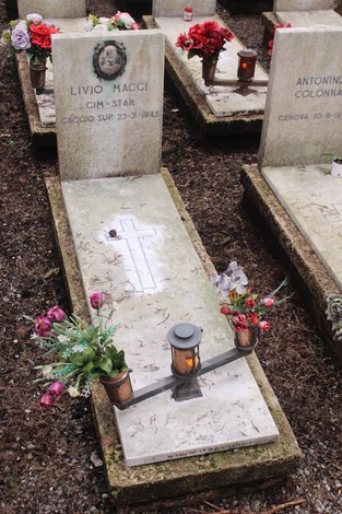 Tombe decorate con fiori e candele, dedicate ai caduti per la Libertà in un cimitero.
