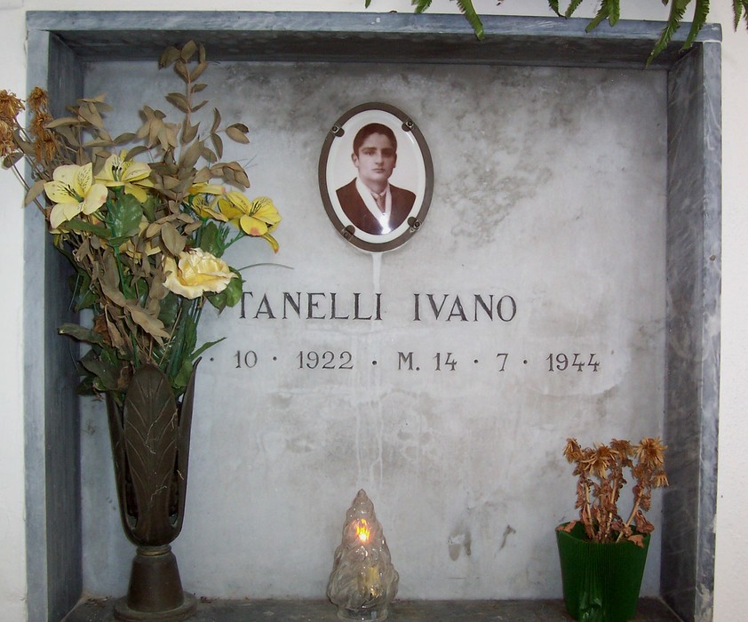 Cappella dedicata ai caduti partigiani, con un omaggio floreale e una foto commemorativa.