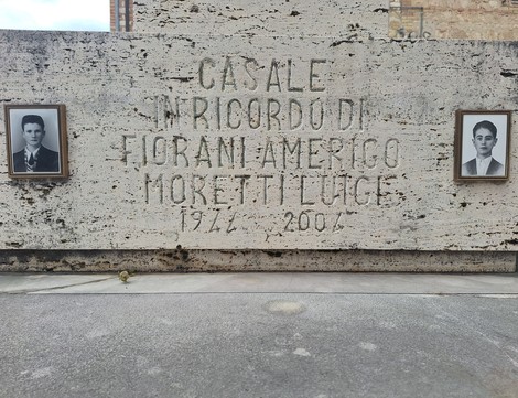 Monumento dedicato a Fiorani e Moretti, con due ritratti incorniciati su fondo di pietra.