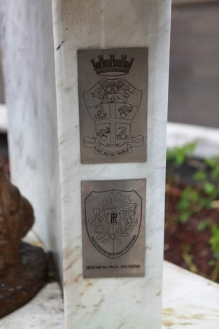 Monumento a D'Acquisto, basamento in marmo con stemmi e targhe commemorative.