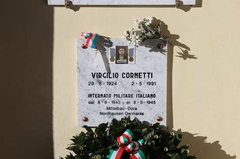 Lapidi commemorative al Cimitero di Cornalba, con decorazioni floreali e drappi tricolori.